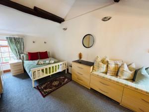 a bedroom with a bed and a couch at Agniti Cottage in Derby
