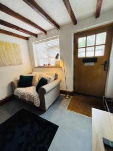 a living room with a couch and a door at Agniti Cottage in Derby