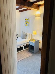 a bedroom with a bed and a lamp on a table at Agniti Cottage in Derby