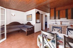 a living room with a couch and a kitchen at Bon repós B11 in Cala en Bosc