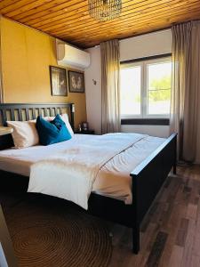 a bedroom with a large bed with blue pillows at La Clairiere - Erezee- 3 bedroom chalet in Érezée
