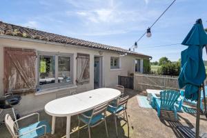 a patio with a table and chairs and an umbrella at Gîte De L'etrie in Mauves-sur-Loire