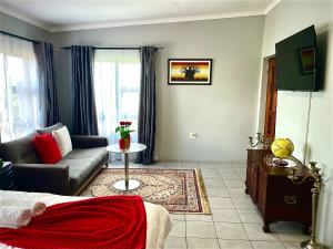 a living room with a couch and a table in it at Pinnacle Pearl View Cottage in Johannesburg