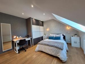 a bedroom with a bed and a desk with a desk at Le Garage & Spa Silver in Gondreville