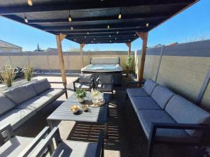 a patio with couches and a table and a grill at Le Garage & Spa Silver in Gondreville