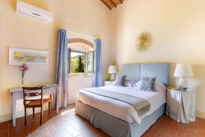 a bedroom with a bed and a table and a window at Riant Relais de Charme in Greve in Chianti