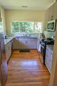 a kitchen with white cabinets and a wooden floor at Cozy Huguenot Hideaway in Huguenot
