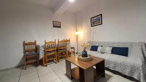 a living room with a couch and a table and chairs at Sylvia's houses in Kalymnos