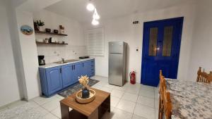a kitchen with blue cabinets and a stainless steel refrigerator at Sylvia's houses in Kalymnos +85 photos