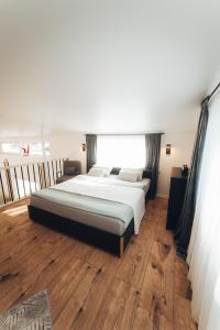 a bedroom with a large bed and a wooden floor at AMRAI Magnetic in Ventspils