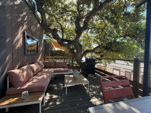 Eine Couch steht auf einer Terrasse neben einem Baum in der Unterkunft Ethan in Saint-Raphaël