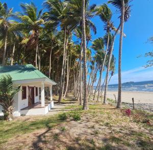 a small house on the beach with palm trees at Rancho Primavera in Cuatro Esquinas