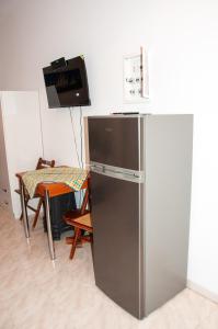 a stainless steel refrigerator in a kitchen with a table at Arcadia Coastal Studio by ΜΡS in Xiropigado