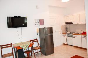 a kitchen with a refrigerator and a table and chairs at Arcadia Coastal Studio by ΜΡS in Xiropigado +10 photos