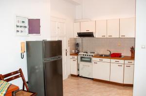 a kitchen with a stainless steel refrigerator and white cabinets at Arcadia Coastal Studio by ΜΡS in Xiropigado