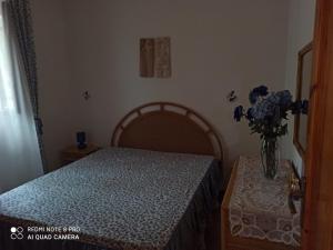 a bedroom with a bed and a vase of flowers at Villa tra le dune di Campomarino in Campomarino +6 photos