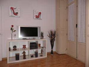 una sala de estar con TV en un estante blanco en Apartamento Montaño 4 Wifi gratis y 2 Baños, en Málaga