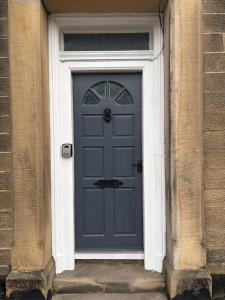 a blue door in a brick building at Union Street Apartment in Hawick