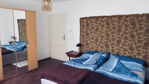 a bedroom with a bed and a large mirror at FLY Vendégház in Szólád