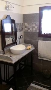 a bathroom with a sink and a mirror on a counter at Il Dammuso di Tracino in Pantelleria +77 photos