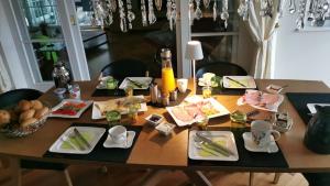 a wooden table with plates of food on it at Landhaus am Bach in Sulzberg