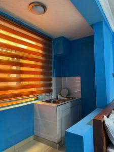 a kitchen with blue and orange walls and a sink at 247Hotel Apartments in Accra
