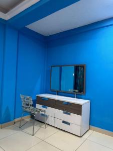a blue room with a desk and a chair at 247Hotel Apartments in Accra