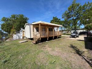 a tiny house with a porch on a yard at La Cabane in Claouey