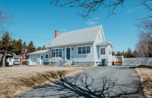 a white house with a white fence at Cherry Lane Cottage | 3 Bed & 2 Bath in Foxtrap