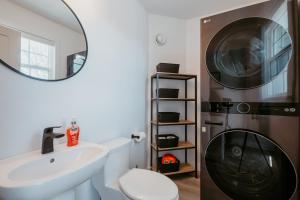 a bathroom with a sink and a washing machine at Cherry Lane Cottage | 3 Bed & 2 Bath in Foxtrap +38 photos
