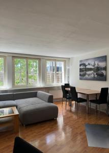 a living room with a couch and a table at Garden House Interlaken in Interlaken