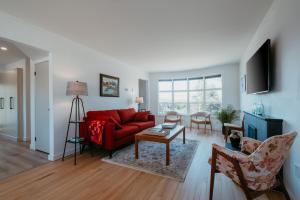 a living room with a red couch and a table at Cherry Lane Cottage | 3 Bed & 2 Bath in Foxtrap