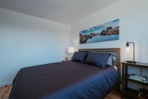 a bedroom with a bed and a painting on the wall at Cherry Lane Cottage | 3 Bed & 2 Bath in Foxtrap
