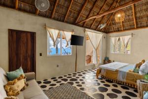 a bedroom with a bed and a couch and windows at Panchos Paradise in Puerto Vallarta