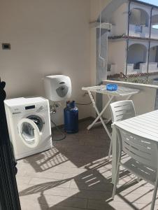 a washing machine sitting on a patio with a table at Little paradise apartment with pool in Orosei