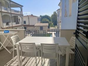 a white table and chairs on a balcony at Little paradise apartment with pool in Orosei