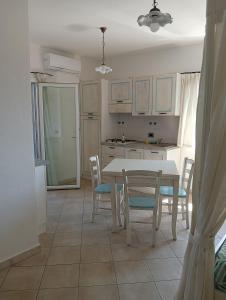 a kitchen and dining room with a table and chairs at Little paradise apartment with pool in Orosei