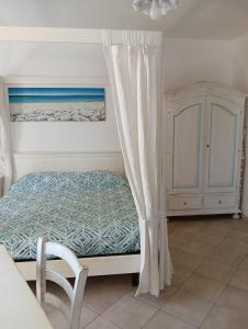a bedroom with a bed with a curtain and a cabinet at Little paradise apartment with pool in Orosei +14 photos