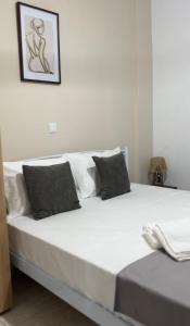 a bed with white sheets and pillows in a room at Diktamo Coast Living in Ofrínion
