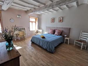 a bedroom with a bed and a table and chairs at Gîtes Chambres d'hôtes de charme B&B - La Cense du Pont - Campagne de Lille in Bachy