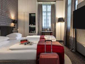 a hotel room with a bed with a suitcase at Mercure Vienna First in Vienna +72 photos