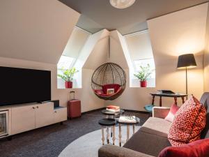 a living room with a couch and a tv at Mercure Vienna First in Vienna