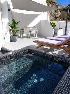 a swimming pool with a table and a swimming poolvisor at Ecolodge Cave House in Vóthon