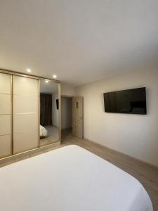 a bedroom with a white bed and a flat screen tv at Vivat in Berehove