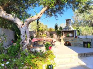 a garden with a table and a tree at Suite Home Villa Paxos in Gaios