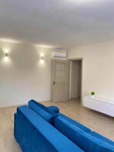a blue couch in a living room with a door at Vivat in Berehove