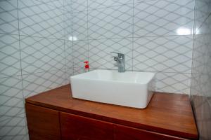 a bathroom with a white sink on a wooden counter at Be Home Apartments in Nkoanrua +21 photos