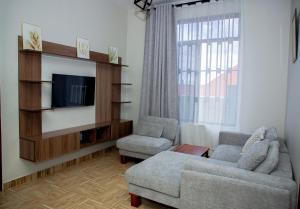 a living room with a couch and a tv at Be Home Apartments in Nkoanrua