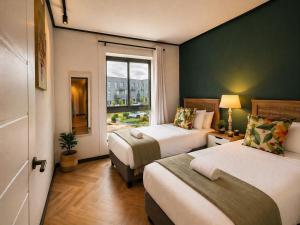 a hotel room with two beds and a window at ZALS- Nine Palms -Luxury Two Bed in Cape Town