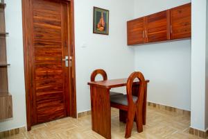 a wooden table and chair next to a door at Be Home Apartments in Nkoanrua